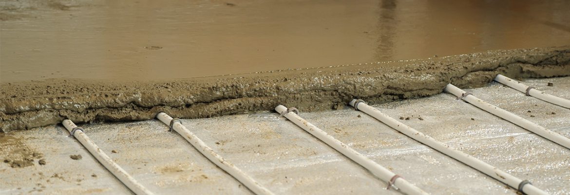 Underfloor heating pipes being covered with screed.